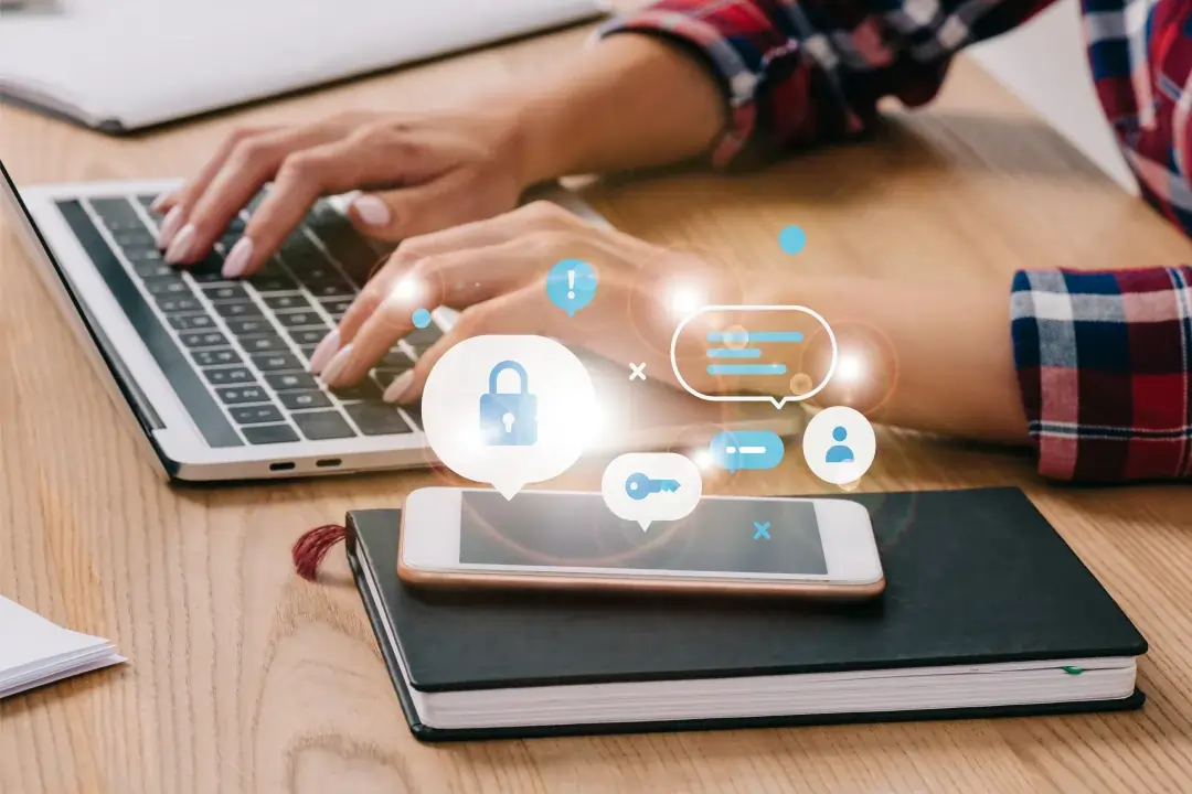 Persona trabajando en laptop con icono de candado, representando seguridad y privacidad de datos.